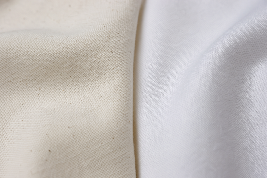 Close-up of cotton and cotton blend fabric swatches side by side showing texture differences for streetwear garments
